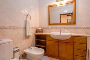 a bathroom with a sink and a toilet and a mirror at BE LOST - Guest House in Pedra Do Ouro