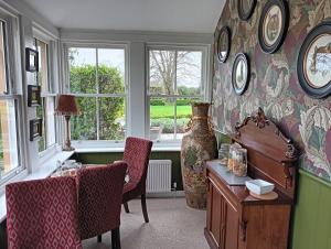 een kamer met een bureau, stoelen en ramen bij Lucker mill house in Lucker