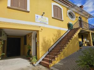 un edificio amarillo con una escalera delante en B&B Villa Rosina, en Satriano di Lucania