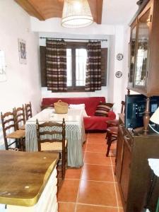 sala de estar con mesa y sofá rojo en 6 bedrooms house with balcony at Quesada, en Quesada