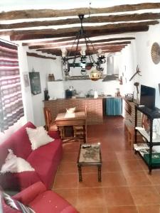 sala de estar con sofá rojo y mesa en 6 bedrooms house with balcony at Quesada, en Quesada