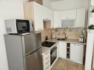 a kitchen with white cabinets and a stainless steel refrigerator at Kristy's Place in Crikvenica