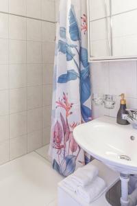 a bathroom with a sink and a shower curtain at Special PICCO PICASSO Apartment Basel, Bahnhof Grossbasel 10-STAR in Basel +48 photos