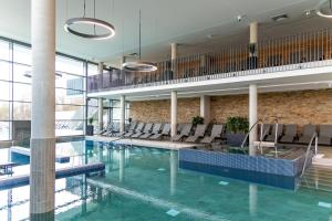 a large swimming pool with chairs in a building at enso Hotel in Ingolstadt