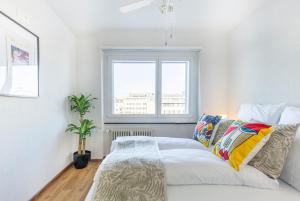a white bedroom with a bed and a window at Special PICCO PICASSO Apartment Basel, Bahnhof Grossbasel 10-STAR in Basel