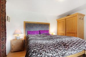 a bedroom with a large bed with purple pillows at Ferienwohnung beim Roana in Inzell