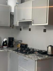 a kitchen with white cabinets and a counter top at Furnished apartment in Marrakesh in Tamensourt