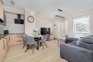 ein Wohnzimmer mit einem Tisch und einem Sofa in der Unterkunft Cosy and Bright Apartment with Parking in Poznan by Renters in Posen