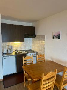 a kitchen with a wooden table and a table and chairs at Bellevue PLEASANT & COMFORTABLE apartments in Veysonnaz