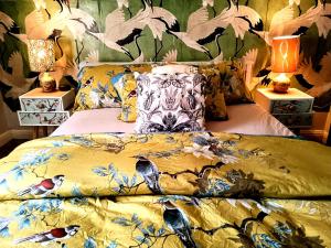a bed with a yellow blanket with birds on it at 4 bedroom period Townhouse in the heart of Hebden in Hebden Bridge