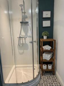 a shower with a glass door in a bathroom at Wyndgrove House in Seahouses