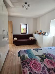 ein Schlafzimmer mit einem Bett und einem Sofa mit Rosen in der Unterkunft Hiška pod murvo - Kraški rob in Črni Kal