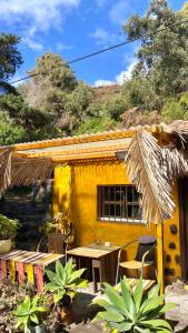 a yellow house with a table and chairs in front of it at Studio Mazo La Habitación in Lodero