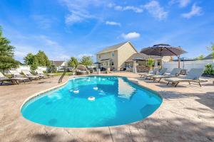 a swimming pool with chairs and an umbrella at Your Resort On Gala Family Fun with Spa and Pool in Appleton