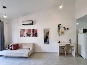 uma sala de estar branca com um sofá e uma secretária em RIO Star View, Gamboa, Little Africa 2 no Rio de Janeiro