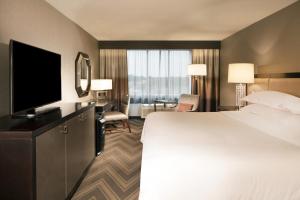 a hotel room with a large bed and a flat screen tv at Sheraton Bucks County Langhorne in Langhorne