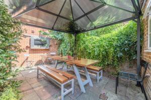 a patio with a table and a bench and an umbrella at Rustic Royal Windsor Castle Cottage alfresco dining characterful in Windsor