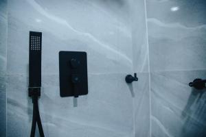 una puerta de ducha de cristal con un objeto negro. en DE LEVERAGE HOTEL & SUITES en Lagos