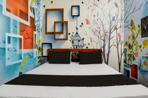 RudrapurにあるOYO WELCOME GUEST HOUSEのベッドルーム1室(壁に絵画が飾られたベッド1台付)