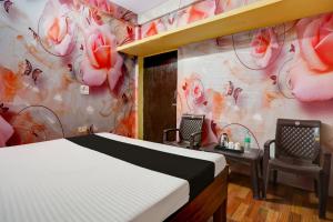 una camera con letto e scrivania con sedie di OYO WELCOME GUEST HOUSE a Rudrapur