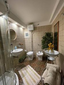 a bathroom with a shower and a toilet and a sink at Inn The Garden in Catania