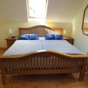 a bedroom with a large bed with blue pillows at Mizen View in Goleen