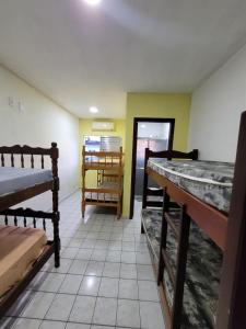 Pokój z 2 łóżkami piętrowymi i stołem w obiekcie Cantinho do Mar Pousada w mieście Bertioga