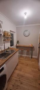a kitchen with a sink and a table with stools at 3 Bed Home in Heart of Cardiff in Cardiff