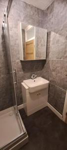 a bathroom with a sink and a shower and a mirror at 3 Bed Home in Heart of Cardiff in Cardiff