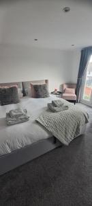 sypialnia z 2 łóżkami i ręcznikami w obiekcie 3 Bed Home in Heart of Cardiff w Cardiff