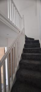 a staircase in a house with a white railing at 3 Bed Home in Heart of Cardiff in Cardiff