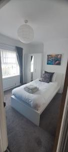 a white bed in a room with a window at 3 Bed Home in Heart of Cardiff in Cardiff