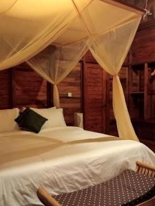 a bedroom with a white bed with a canopy at Loka Amertha in Sidemen