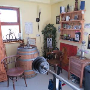 um quarto com um barril e duas cadeiras e uma lareira em Mizen View em Goleen