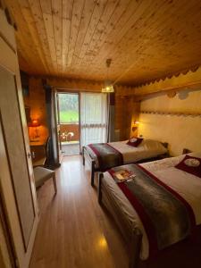 a hotel room with two beds and a window at Hotel Le Ferraillon in Abondance