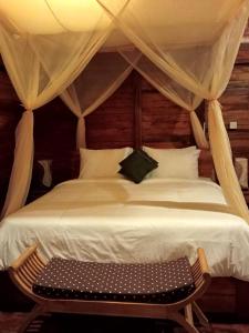 1 dormitorio con cama blanca grande y banco en Loka Amertha, en Sidemen