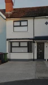 a white house with a window and a garage at 3 Bed Home in Heart of Cardiff in Cardiff