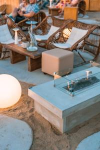 un patio avec des chaises, des tables et des tables. dans l'établissement OV Suites "by Checkin", à Chersónissos