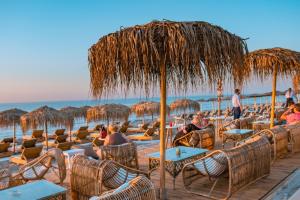 - un groupe de personnes assis sur des chaises sous un parasol sur la plage dans l'établissement OV Suites "by Checkin", à Chersónissos 60 autres photos