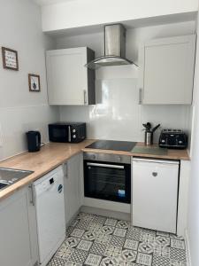 a kitchen with white cabinets and a stove top oven at Class Apartments in Peterhead