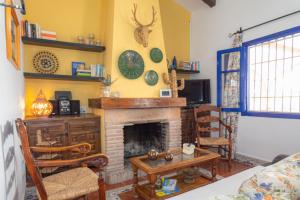 a living room with a fireplace and a table and chairs at Cortijo Fernando in Frigiliana