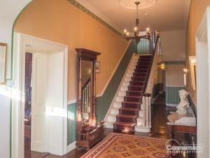 einen Flur mit einer Treppe in einem Haus in der Unterkunft Kill House, Kingstown in Clifden