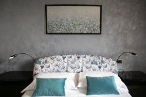 Un dormitorio con una cama con dos almohadas azules. en IseoLakeRental - Casa Angelica, en Riva di Solto 27 fotos más