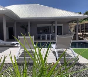 a house with two chairs and a pool at Nakolodge -3 chambres - piscine et jardin privatifs in Sainte-Anne +105 photos