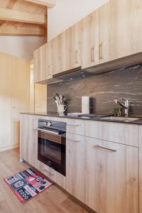 uma cozinha com armários de madeira e um forno em Studio rénové à Grimentz em Grimentz