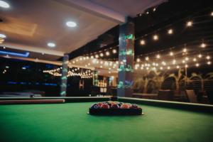 a pool table with a bowl of balls on it at DE LEVERAGE HOTEL & SUITES in Lagos