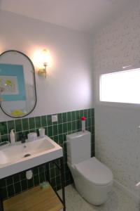 Un baño con lavabo, inodoro y espejo. en Clos Emilie, en La Seyne-sur-Mer