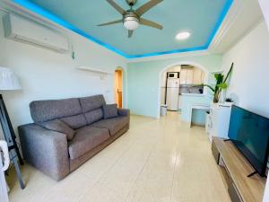 a living room with a couch and a ceiling fan at La Manga apartamento Siesta in San Blas