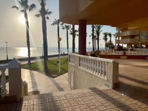 a view of a beach with palm trees and a building at La Manga apartamento Siesta in San Blas