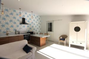 Una sala de estar con un sofá y una cocina. en Clos Emilie, en La Seyne-sur-Mer